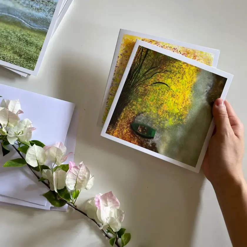 Main tenant des cartes postales au desuus table fleurie avec cartes